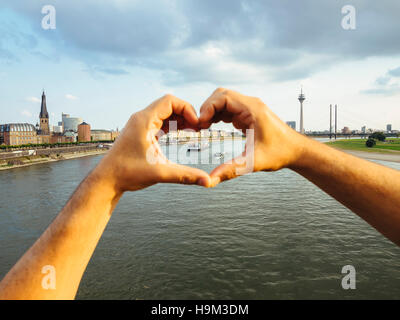 Germania, Duesseldorf, mani formando un cuore il framing navi sul Fiume Reno Foto Stock