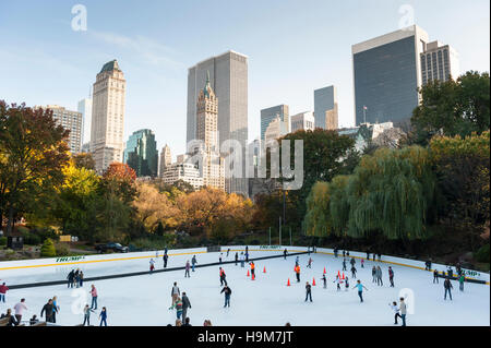 Wollman pista di pattinaggio su ghiaccio durante il giorno con persone di pattinaggio con sullo skyline di New York in background Foto Stock