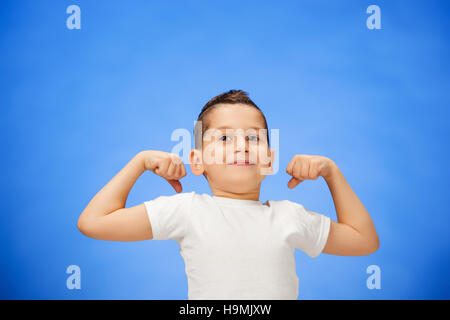 Bellezza sport sorridente bambino ragazzo che mostra il suo bicipite Foto Stock