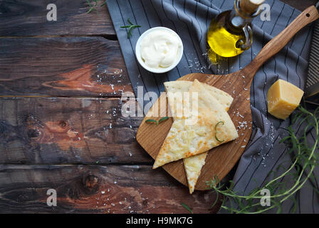 Focaccia con olio d'oliva, Parmigiano, sause bianco e rosmarino. In casa italiana tradizionale focaccia pane sul tovagliolo di lino. Foto Stock