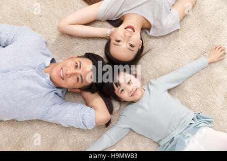 La famiglia felice giacente a terra Foto Stock