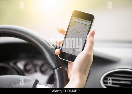 Close-up di femmine della mano che tiene il suo telefono con sistema di navigazione Foto Stock