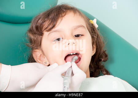 Dentista esaminando la ragazza denti a dental clinic Foto Stock