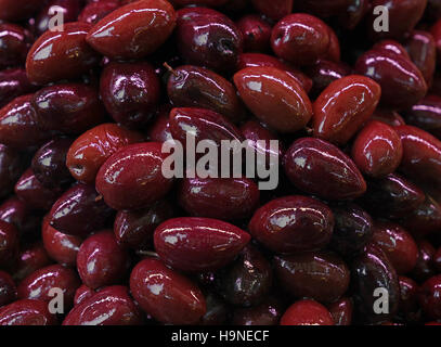 Kalamata Greco nero rosso lucido intero delle olive in olio vicino fino sfondo, sul mercato al dettaglio di stallo, display a basso angolo di visione Foto Stock