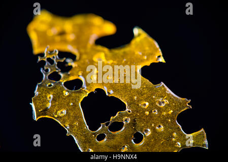 Close up dettaglio della marijuana concentrato di olio aka frantumare isolati su sfondo nero Foto Stock