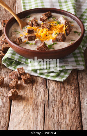 Zuppa di birra con salsiccia e formaggio cheddar e crostini in una ciotola vicino sul piano verticale. Foto Stock