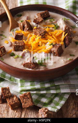 La birra tradizionale zuppa con pancetta e formaggio cheddar e crostini in una ciotola vicino sul tavolo. In verticale Foto Stock