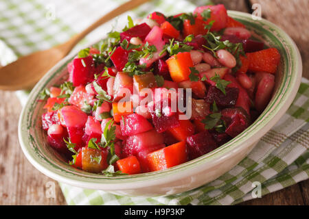 Insalata di verdure bollite con barbabietole, carote, fagioli, patate e cipolle in una ciotola macro. orizzontale Foto Stock