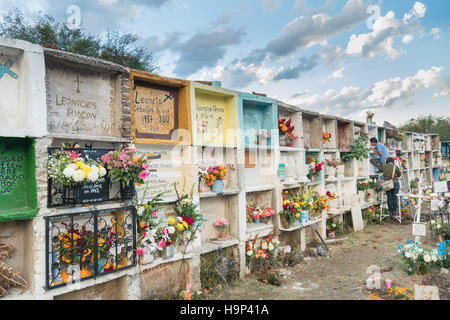 Una famiglia messicana organizza fiori sulla tomba di un relativo nella Nuestra Se-ora de Guadalupe cimitero durante il giorno dei morti festival il 1 novembre 2016 in San Miguel De Allende, Guanajuato, Messico. La settimana di festa è un momento in cui i messicani benvenuti i morti alla messa a terra per una visita e celebrare la vita. Foto Stock