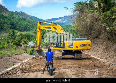 Un escavatore viene utilizzato per l'architettura paesaggistica in un cantiere di costruzione di strade vicino ad Atadei a Lembata, Nusa Tenggara orientale, Indonesia. Foto Stock