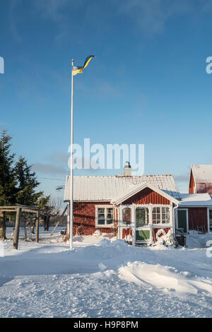 Neve e un piccolo cottage in inverno. Fagelsundet villaggio di pescatori sulla costa di Roslagen, Uppland, Svezia e Scandinavia Foto Stock