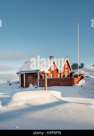 Neve e un piccolo cottage in inverno. Fagelsundet villaggio di pescatori sulla costa di Roslagen, Uppland, Svezia e Scandinavia Foto Stock