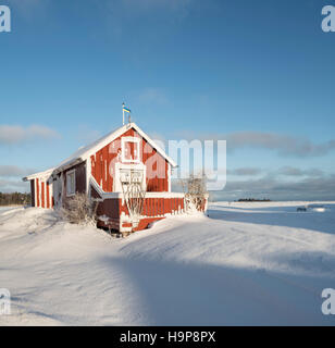 Neve e un piccolo cottage in inverno. Fagelsundet villaggio di pescatori sulla costa di Roslagen, Uppland, Svezia e Scandinavia Foto Stock