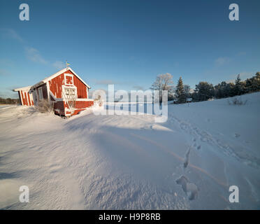 Neve e un piccolo cottage in inverno. Fagelsundet villaggio di pescatori sulla costa di Roslagen, Uppland, Svezia e Scandinavia Foto Stock