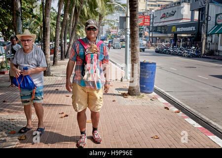 Carino e divertente immagine di un uomo prendendo il suo cane per una passeggiata utilizzando un cablaggio. Thailandia SUDEST ASIATICO Foto Stock