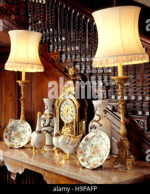 Vista parziale della sala interna a Antony House che mostra il marmo top table, ceramica oche, orologio, lampade da tavolo, vasi e le piastre. Foto Stock