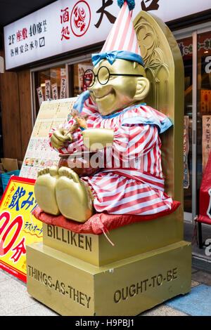 Giappone, Osaka, Shinsekai. Billiken, Lucky mascot, 'cose come dovrebbero essere' statua al di fuori sulla strada. Vestito come corona. Foto Stock