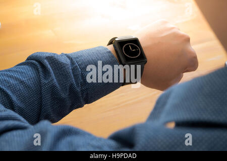 Man mano che indossa eleganti smartwatch Foto Stock