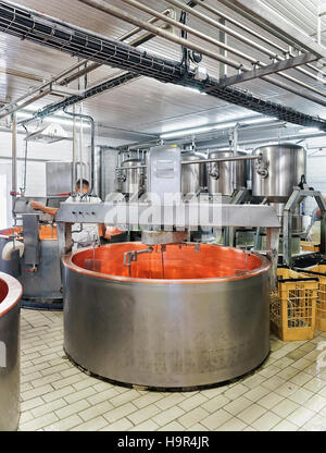 Serbatoio vuoto per l'elaborazione Gruyere de Comte il formaggio nel caseificio FRANCHE COMTE, Borgogna, in Francia. Casaro sullo sfondo Foto Stock