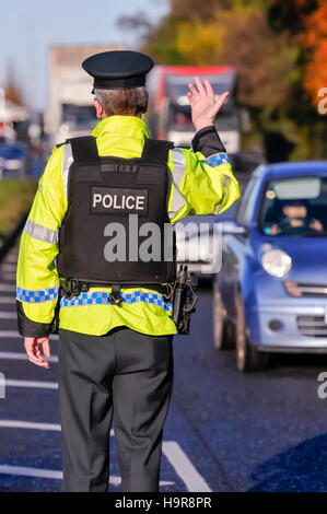 Belfast, Irlanda del Nord. 24 nov 2016 - Un PSNI armati officer onde sul traffico durante un veicolo checkpoint. Credito: Stephen Barnes/Alamy Live News Foto Stock