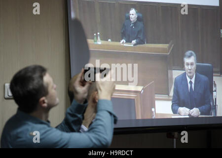 Kiev, Ucraina. 25 Nov, 2016. Un uomo prende la foto di un ex presidente ucraino Viktor Yanukovych, come egli testimonia su uno schermo da via live video link da Russia, come frequenta una audizione durante una sessione di prova in una corte distrettuale di Kiev, Ucraina, 25 novembre 2016. Svyatoshinsky corte distrettuale di Kyiv ha organizzato un'audizione nel caso di eventi di Maidan, interrogando testimoni ex ucraino Viktor Yanukovych in caso di cinque ex Berkut riot funzionari di polizia, che sono accusati di aver ucciso attivisti Maidan nel febbraio 2014. Credito: Serg Glovny/ZUMA filo/Alamy Live News Foto Stock