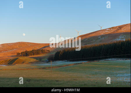 Turbine di Clyde wind farm in Lanarkshire in Scozia con la luna piena sorge dietro Foto Stock