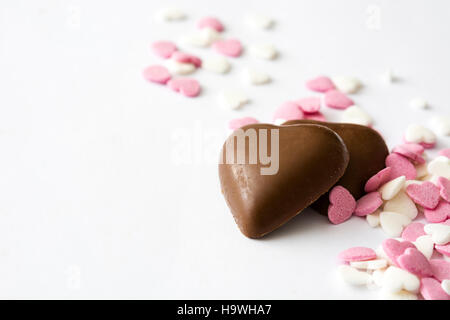 Bonbons di cioccolato a forma di cuore e caramelle su sfondo bianco Foto Stock