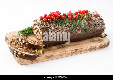 Il cioccolato yule log torta di Natale con ribes rosso isolato Foto Stock