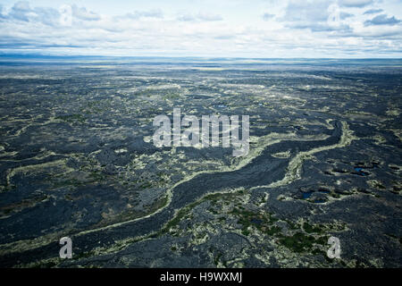 Il Bering Land Bridge, un tempo un collegamento terrestre tra Asia e Nord America, è raffigurato in questa fotografia geologica. Il Lost Jim Lava Flow nella catena dell'Alaska mostra il paesaggio vulcanico formatosi milioni di anni fa, mettendo in evidenza la storia naturale e gli antichi eventi geologici che hanno plasmato la regione. Foto Stock