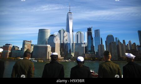 Stati Uniti i marinai a bordo della USN Wasp-classe assalto anfibio nave USS Iwo Jima guardare la Manhattan skyline della città in quanto uomo guide mentre entrando nel porto di New York per i veterani settimana Novembre 10, 2016 nella città di New York, New York. Foto Stock