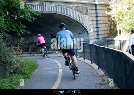 L uomo e la donna in bicicletta sotto il ponte dal canale tra il lago Calhoun e il lago delle isole. Minneapolis Minnesota MN USA Foto Stock