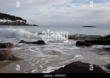 Kristi Rugg cattura una tranquilla scena invernale lungo Ocean Drive a Sand Beach in un parco nazionale degli Stati Uniti. L'immagine mette in risalto il tranquillo paesaggio invernale, con coste innevate e acque calme, sottolineando la bellezza naturale del parco durante i mesi più freddi. Foto Stock