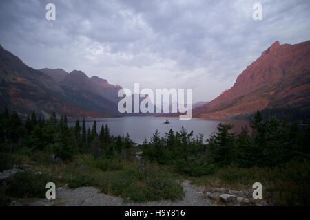 Una vista mozzafiato dalla Wild Goose Island si affaccia sul Glacier National Park. L'immagine evidenzia le aspre montagne del parco, le acque incontaminate e la ricca biodiversità, mostrando la bellezza degli ecosistemi del Glacier National Park. Foto Stock