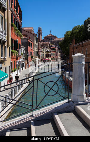 I turisti a piedi lungo un piccolo canale tra i vicoli di Venezia in Italia. Foto Stock