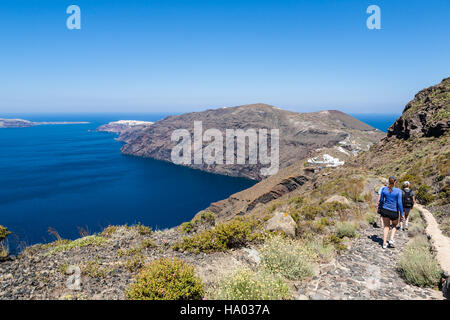 Gli escursionisti a piedi lungo il bordo del vulcano da Fira a Oia sull'isola greca di Santorini su un luminoso giorno caldo e soleggiato Foto Stock