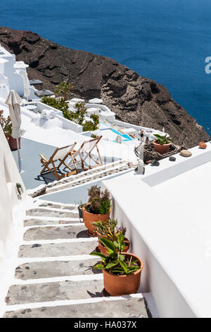 Sedie a sdraio sulla terrazza e giù per le scale di Oia - Santorini, Grecia Foto Stock
