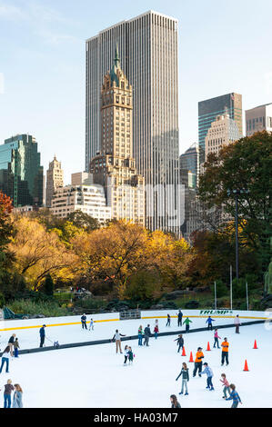 Parco cittadino, pista di pattinaggio su ghiaccio di Wollman durante il giorno con persone che pattinano sullo sfondo con lo skyline di New York City Foto Stock