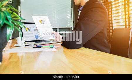 Business uomo al lavoro su un nuovo progetto di design sul portatile in ufficio. Attraente modello usando computer. In stile vintage Foto Stock