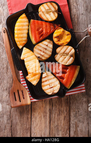 Cibo sano: mela, melone, pera, anguria e pesca su una padella per grigliare macro. vista verticale da sopra Foto Stock