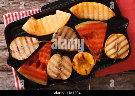 Grigliata di mela, melone, pera, anguria e pesca su una padella per grigliare closeup. Vista orizzontale dal di sopra Foto Stock