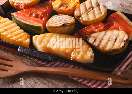 Grigliata di mela, melone, pera, anguria e pesca su una padella per grigliare closeup. orizzontale Foto Stock