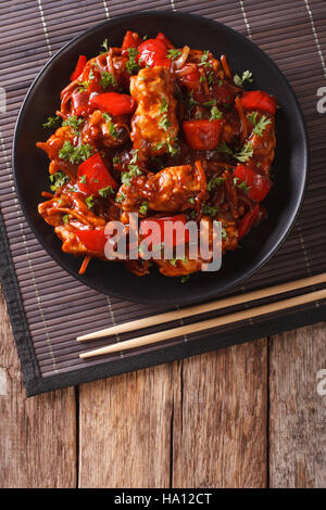 Cibo cinese: la carne di maiale in salsa agrodolce con peperoni, le carote e le cipolle. vista verticale da sopra Foto Stock