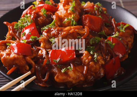 Cibo cinese: la carne di maiale in salsa agrodolce con peperoni, le carote e le cipolle macro. Posizione orizzontale Foto Stock