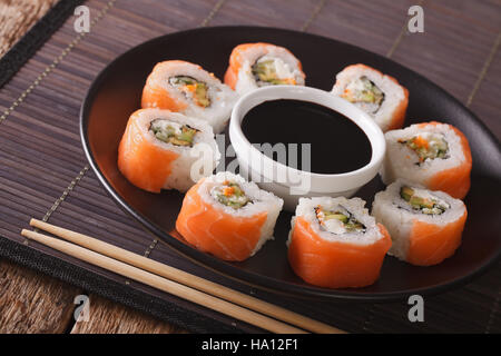 Uramaki. Rotolo di Philadelphia classico. Salmone, formaggio Filadelfia, cetriolo, avocado, tobiko. I sushi giapponesi Foto Stock