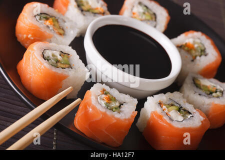 Rotoli di Philadelphia con salmone fresco close-up su una piastra orizzontale. Foto Stock