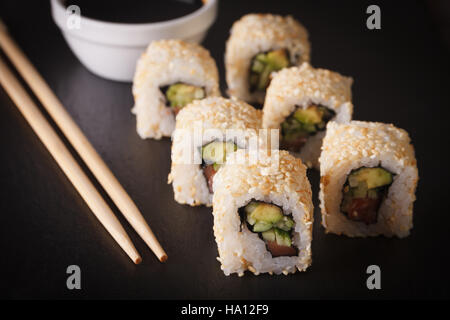 California rotoli con avocado, salmone e semi di sesamo close up orizzontale. Foto Stock