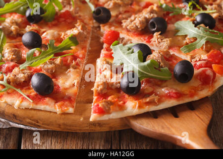Pizza con tonno macro su una tavola di legno orizzontale. Foto Stock