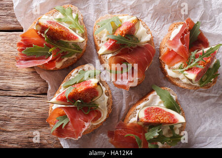 Sandwich con fichi, prosciutto e formaggio cremoso vicino sul tavolo. vista orizzontale dal di sopra Foto Stock