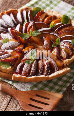 Una deliziosa torta a fette di susine mature vicino sul tavolo. In verticale Foto Stock