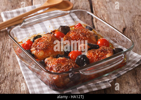 Arrosto di pezzi di pollo con la senape, i pomodori e i funghi selvatici da vicino in una teglia sul tavolo orizzontale. Foto Stock